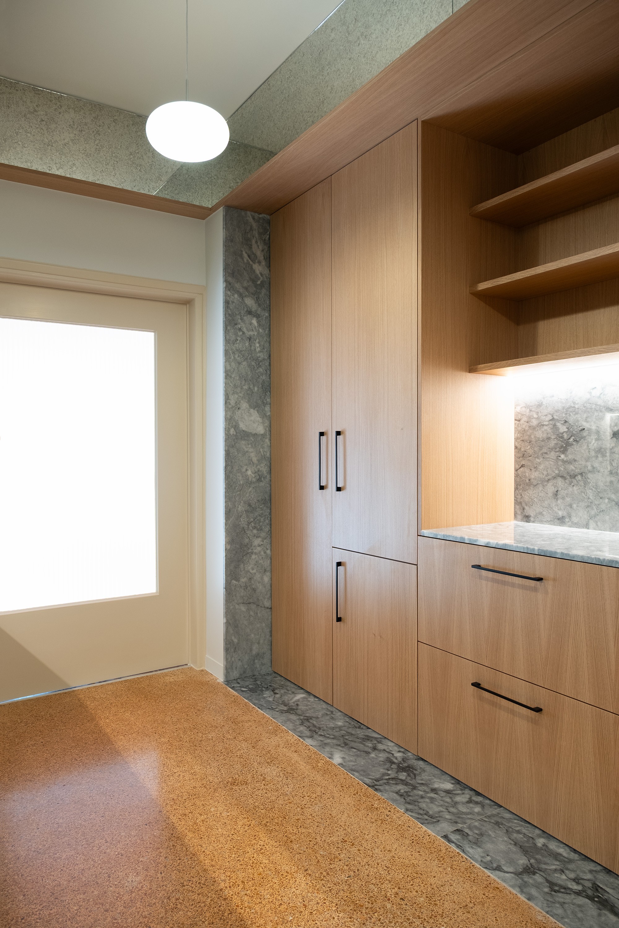 Wooden veneer joinery within a carefully and sensitively refurbished flat in central Athens, Greece including marble and original terrazo floor and sligin glazed door 